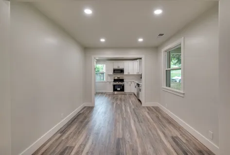 a view of a kitchen with wooden floor electronic appliances and window