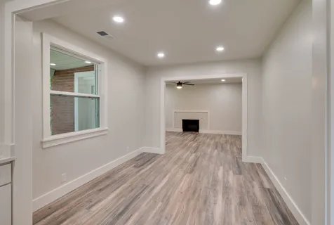 a view of empty room with wooden floor and windows