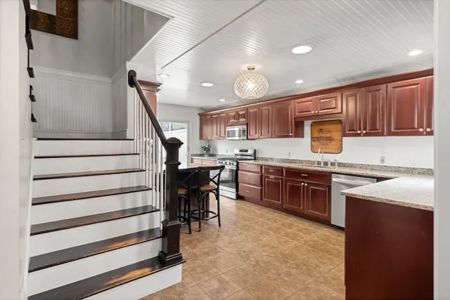 a kitchen with kitchen island granite countertop wooden cabinets and stainless steel appliances