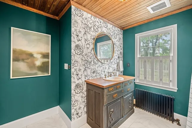 a bathroom with a sink a mirror and a window