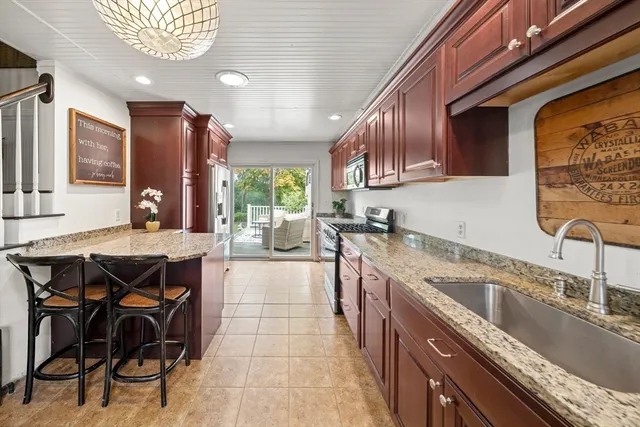 a kitchen with a sink a counter top space appliances and cabinets