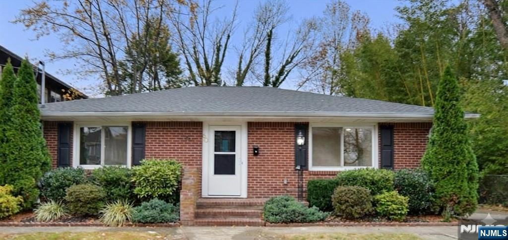 a front view of a house with a tree