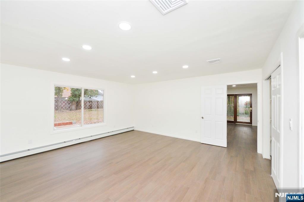 60 Poplar Avenue Hackensack, NJ 07601 - Photo 11 of 21 an empty room with wooden floor and windows