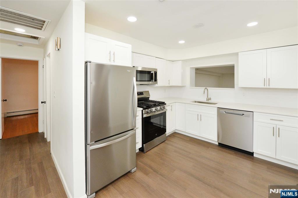 60 Poplar Avenue Hackensack, NJ 07601 - Photo 2 of 21 a kitchen with white cabinets and stainless steel appliances