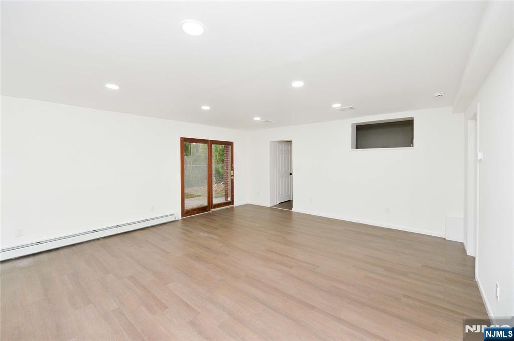 60 Poplar Avenue Hackensack, NJ 07601 - Photo 5 of 21 an empty room with wooden floor and windows