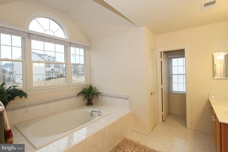 14311 Bubbling Spring Road Boyds, MD 20841 - Photo 14 of 23 a bathroom with a tub a sink and a window