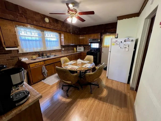 a view of a dining room with furniture a rug and wooden floor