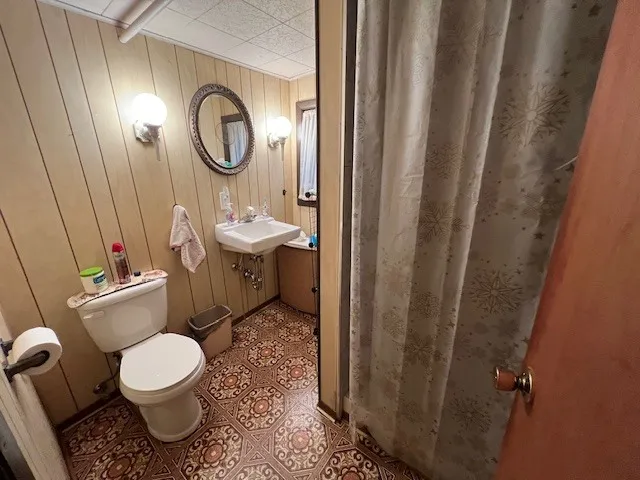 a bathroom with a toilet a sink and a mirror