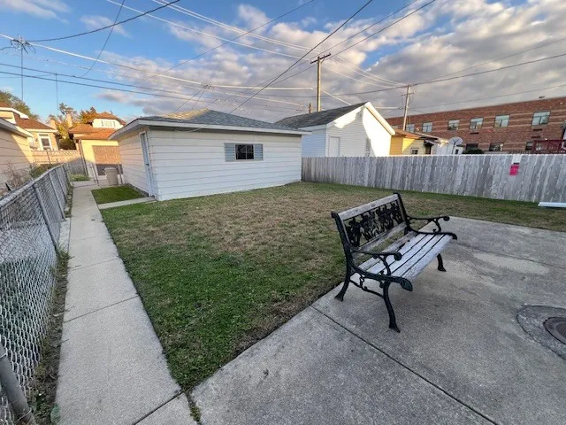 a view of a backyard with furniture and a garden