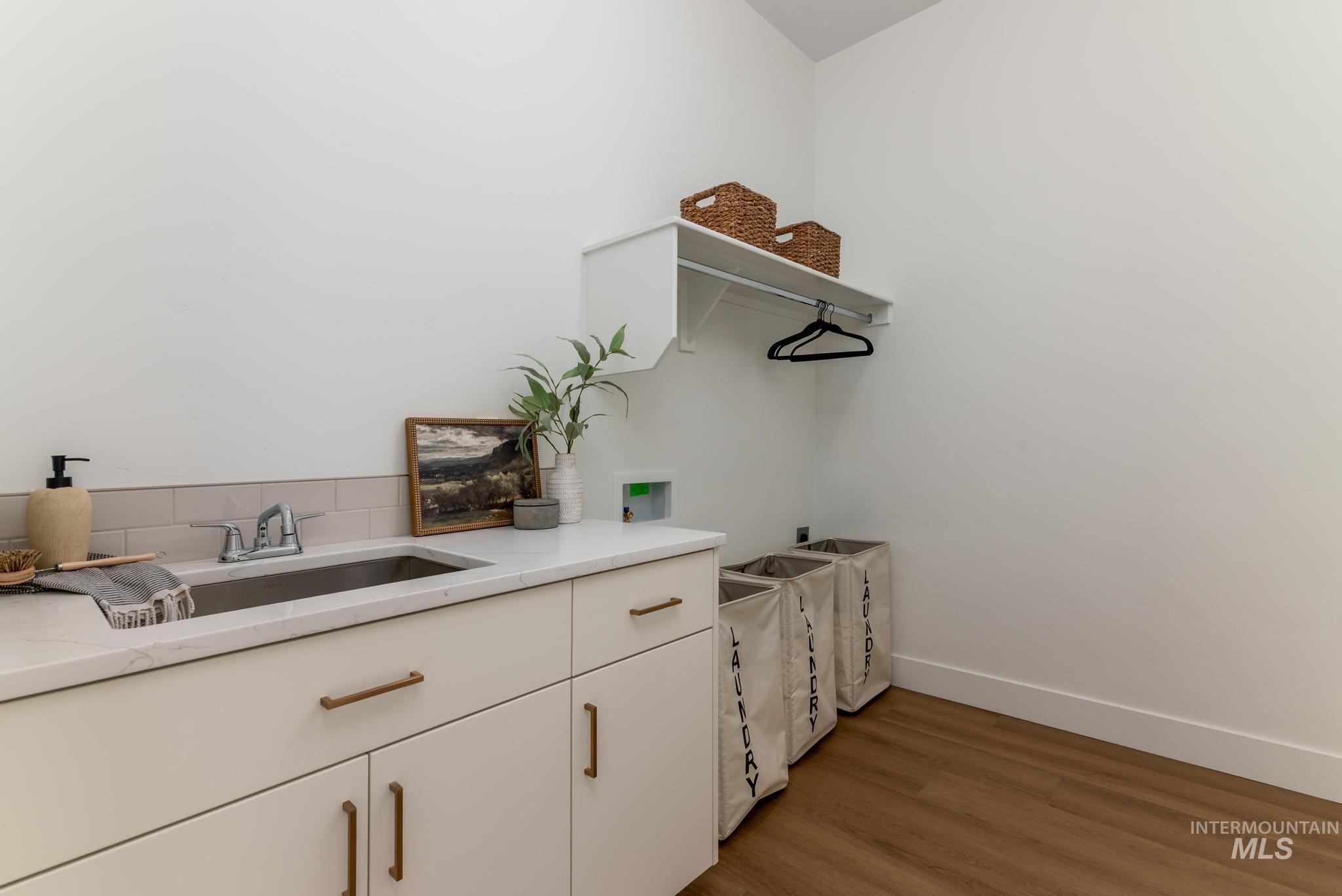 8558 South Silver Smog Way Meridian, ID 83642 - Photo 12 of 13 Laundry area with washer hookup, cabinet space, and light wood-style floors