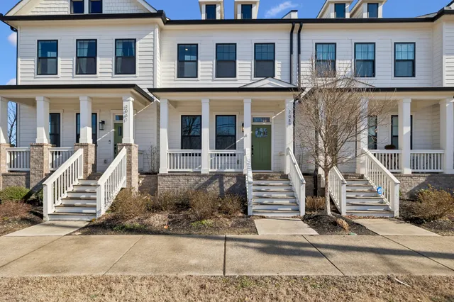 a front view of a house with a tree