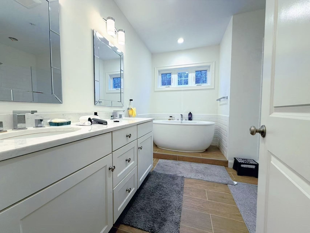 16 Taylor Drive, Unit 1010 Reading, MA 01867 - Photo 15 of 24 a bathroom with a double vanity sink mirror and bathtub