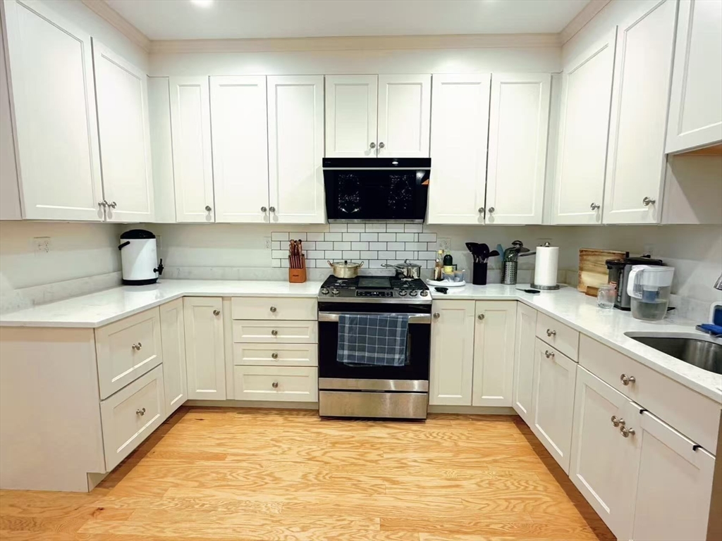 16 Taylor Drive, Unit 1010 Reading, MA 01867 - Photo 2 of 24 a kitchen with granite countertop a sink a stove and cabinets