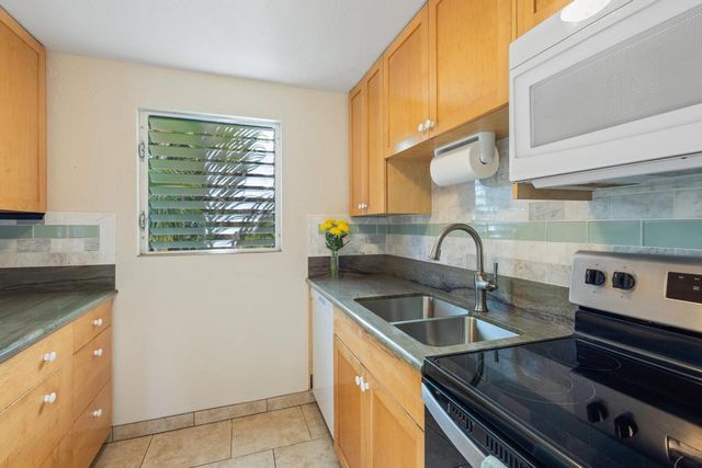 a kitchen with a sink a counter top space cabinets and stainless steel appliances