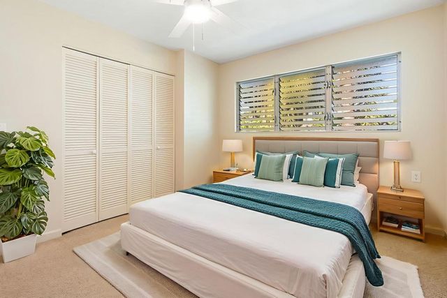 a bedroom with a large bed and a potted plant