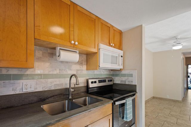 a kitchen with stainless steel appliances granite countertop a sink and cabinets
