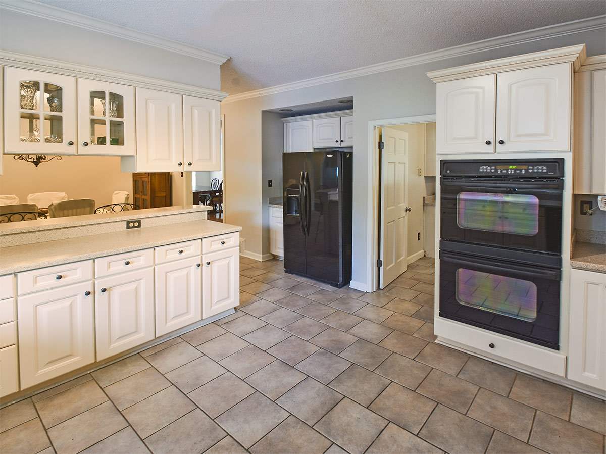 890 South Collierville Arlington Road Collierville, TN 38017 - Photo 12 of 24 Through the single doorway is access to a large laundry area, staircase to 2nd floor, access to a 3 space garage. Moving past the fridge is the entry to the dining room and directly next to the cabinets is a large breakfast area.