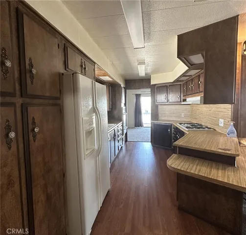 a kitchen with stainless steel appliances a refrigerator and wooden floor