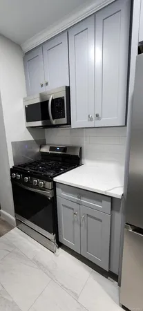 a kitchen with stainless steel appliances granite countertop a stove and a microwave