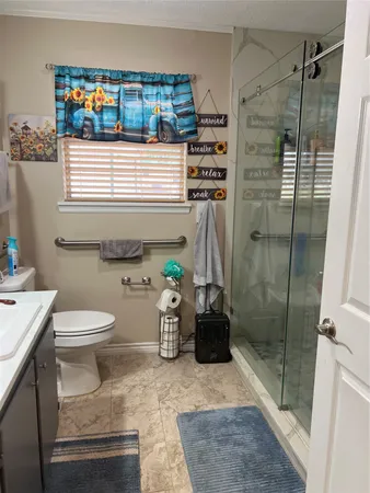 a bathroom with a granite countertop bathtub sink and toilet