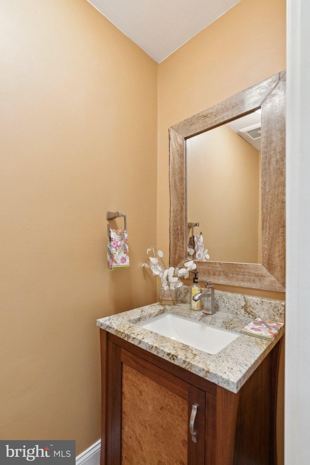 9817 Conestoga Way Potomac, MD 20854 - Photo 16 of 35 a bathroom with a granite countertop sink and a mirror