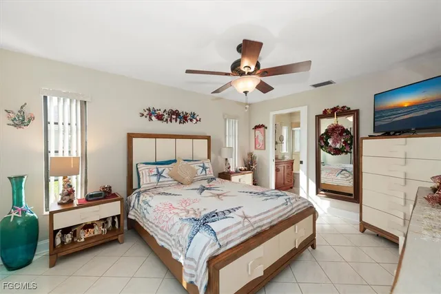 a bedroom with a bed a flat screen tv and a window