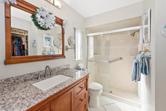 a bathroom with a granite countertop sink a mirror a vanity and a shower
