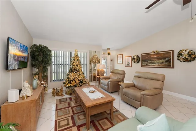 a living room with furniture a flat screen tv and a window