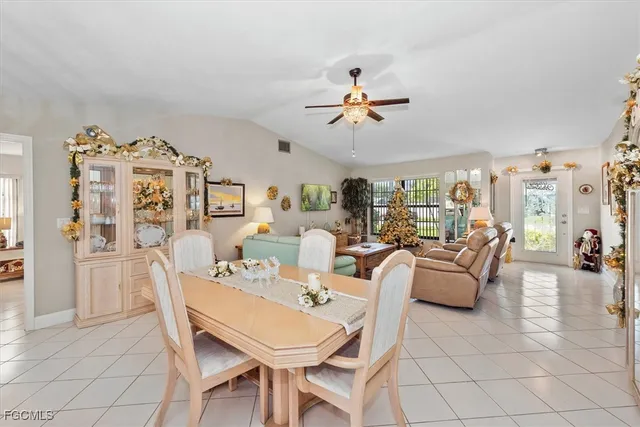 a view of a livingroom and a dining room with furniture wooden floor and a chandelier