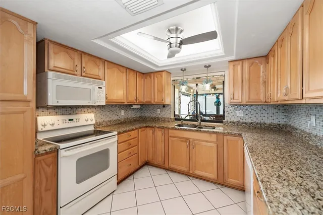 a kitchen with granite countertop cabinets stainless steel appliances a sink and a window