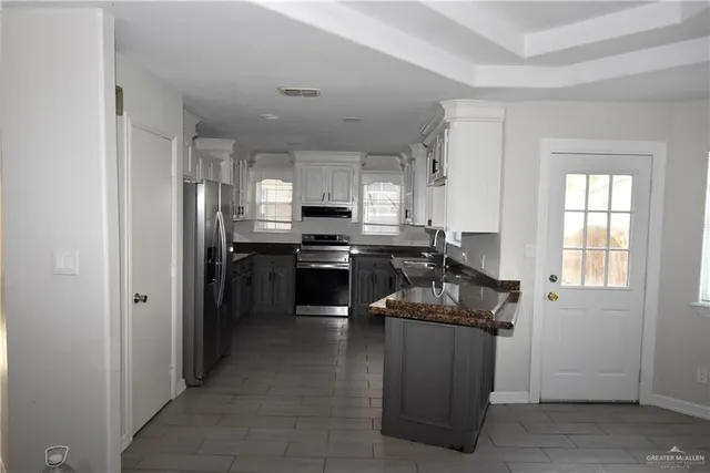 a kitchen with stainless steel appliances granite countertop a stove a sink and a refrigerator