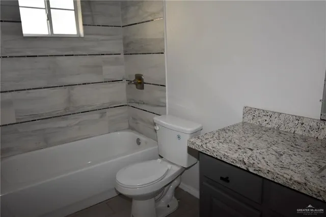 a bathroom with a granite countertop sink toilet and bathtub