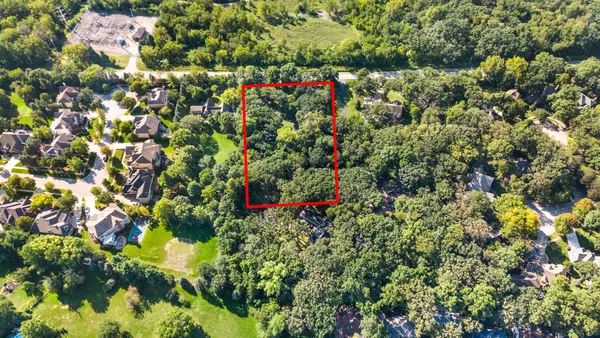an aerial view of residential house with outdoor space and trees all around