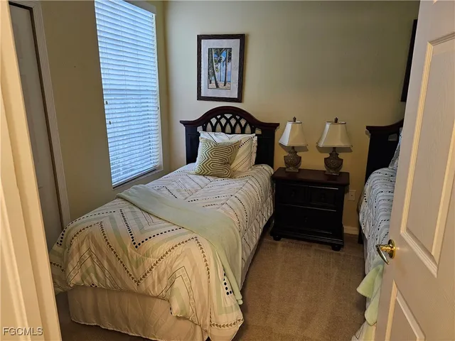 a bedroom with a bed and a lamp on dresser