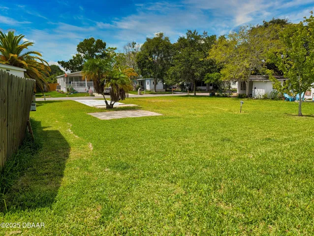 a view of a fountain in front of a house with a big yard