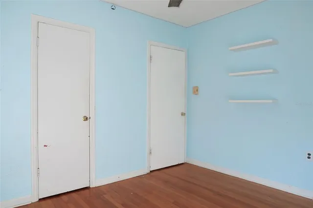 a view of an empty room with wooden floor