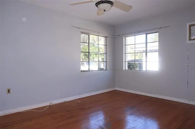 a view of a room with wooden floor and windows