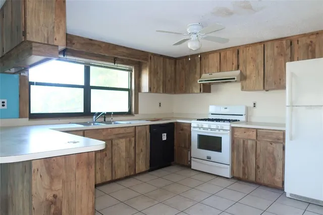 a kitchen with stainless steel appliances granite countertop a stove a sink dishwasher and a refrigerator