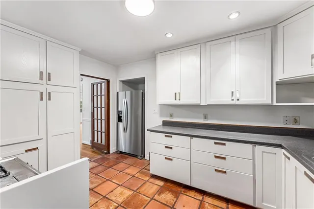 a kitchen with granite countertop white cabinets and white appliances