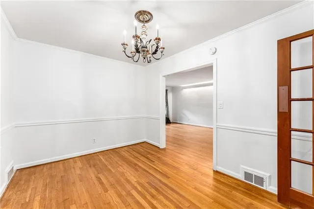 a view of a room with wooden floor and a chandelier