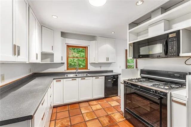 a kitchen with a stove a sink and a microwave