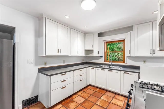 a kitchen with a sink window and cabinets