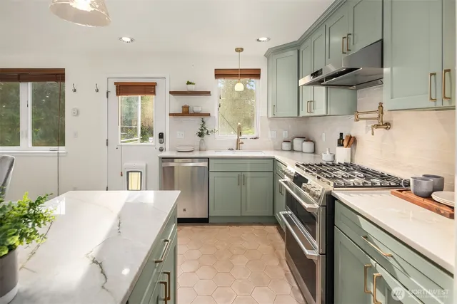 a kitchen with stainless steel appliances a sink stove and cabinets