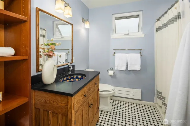 a bathroom with a sink a toilet and mirror