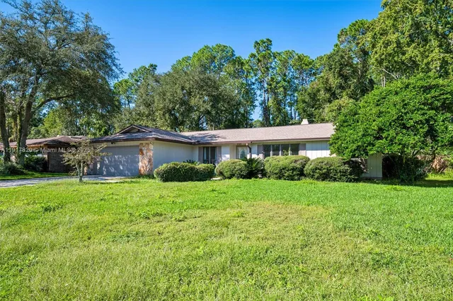 a view of a house with backyard sitting area and garden