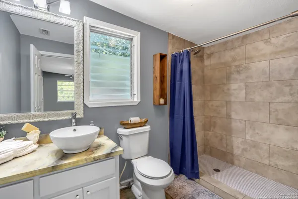 a bathroom with a toilet a sink and mirror