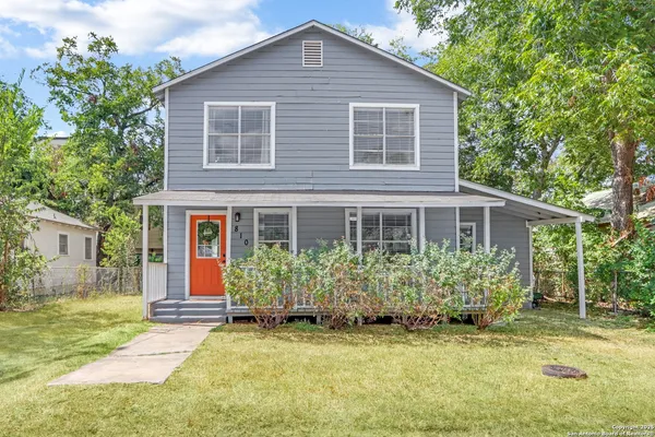a front view of house with yard and trees around