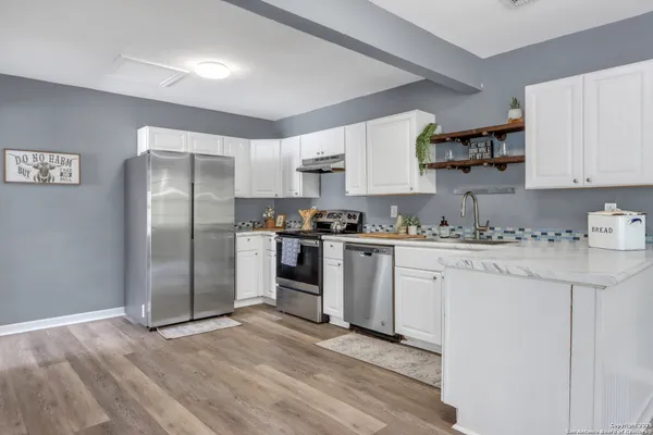 a kitchen with stainless steel appliances granite countertop a refrigerator and a stove top oven