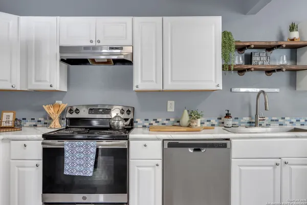 a kitchen with stainless steel appliances granite countertop a sink stove and cabinets