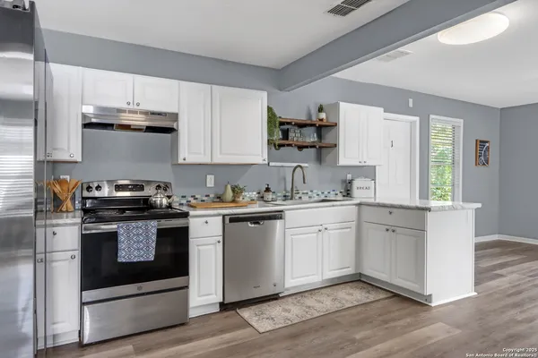 a kitchen with granite countertop white cabinets and appliances